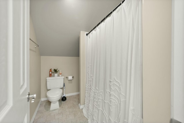 bathroom featuring toilet and vaulted ceiling