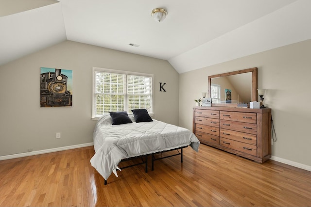 bedroom with lofted ceiling and light hardwood / wood-style flooring