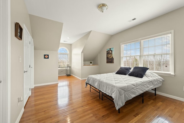 bedroom featuring light wood-type flooring and vaulted ceiling