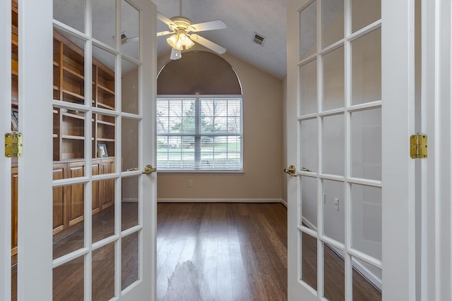 empty room with ceiling fan, french doors, wood-type flooring, and vaulted ceiling