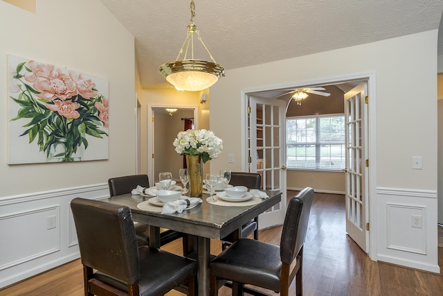 dining area featuring ceiling fan, french doors, dark hardwood / wood-style floors, and a textured ceiling