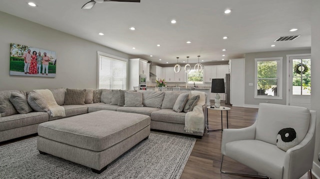 living room with dark hardwood / wood-style flooring and ceiling fan