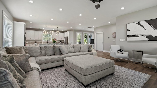 living room with ceiling fan and dark hardwood / wood-style flooring