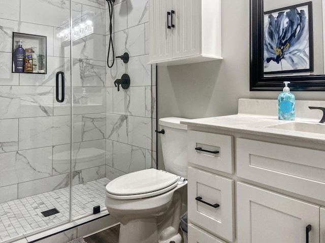 bathroom with a shower with door, vanity, and toilet