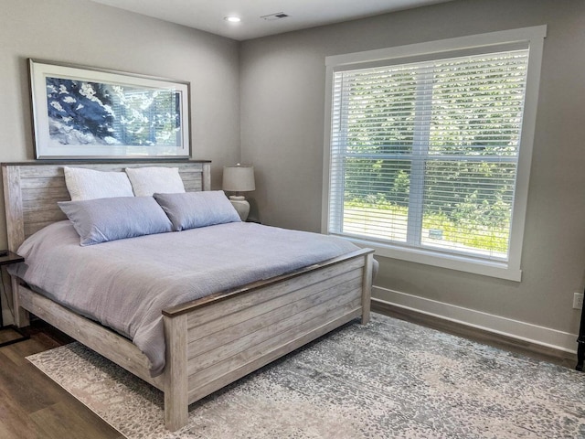 bedroom featuring multiple windows and dark hardwood / wood-style floors