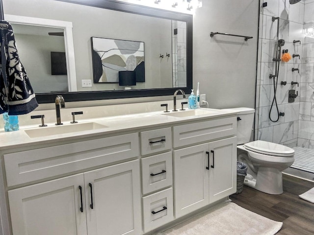 bathroom featuring toilet, vanity, a shower with shower door, and wood-type flooring