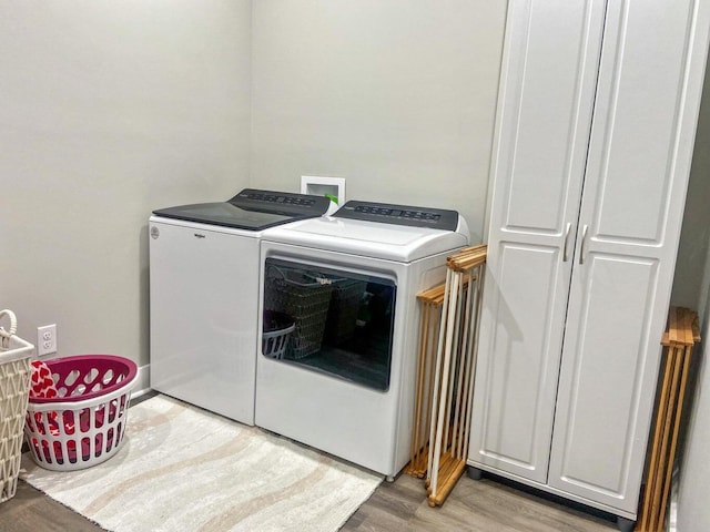 washroom with independent washer and dryer and wood-type flooring