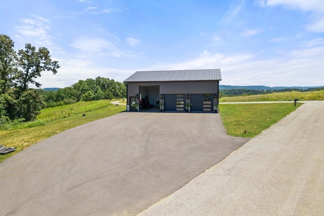 view of front of home with a garage and an outbuilding