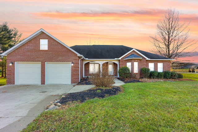 ranch-style home featuring a garage and a yard