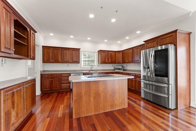 kitchen with a center island, crown molding, sink, dark hardwood / wood-style floors, and stainless steel fridge