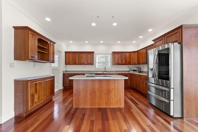 kitchen with crown molding, a center island, dark hardwood / wood-style floors, and appliances with stainless steel finishes