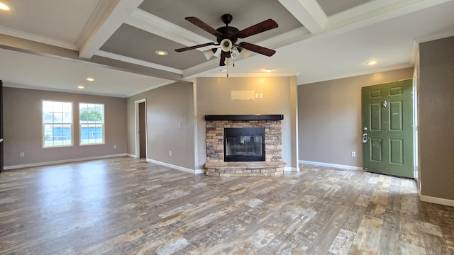 unfurnished living room with a stone fireplace, crown molding, ceiling fan, beam ceiling, and wood-type flooring