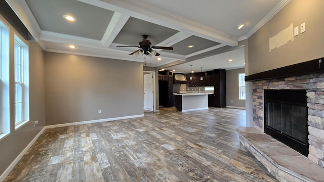 unfurnished living room with coffered ceiling, ceiling fan, a fireplace, beamed ceiling, and wood-type flooring