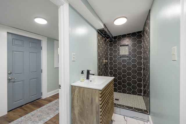 bathroom with vanity, hardwood / wood-style floors, and a tile shower