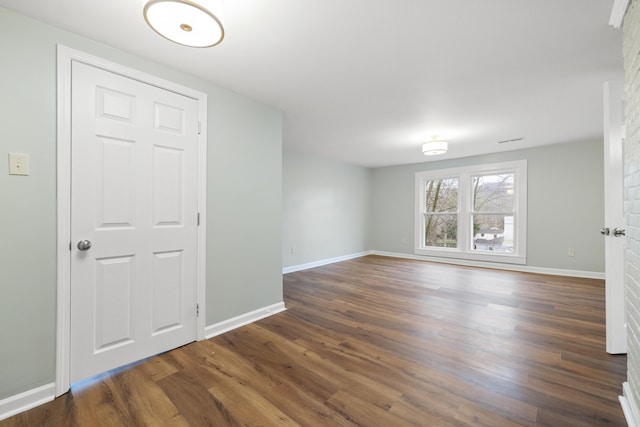 unfurnished room with dark hardwood / wood-style flooring