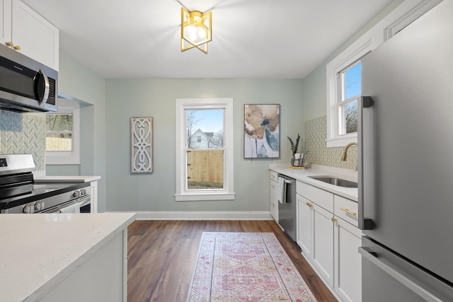 kitchen featuring decorative backsplash, sink, white cabinetry, and stainless steel appliances