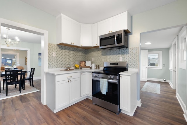 kitchen with white cabinetry, appliances with stainless steel finishes, dark hardwood / wood-style flooring, and an inviting chandelier