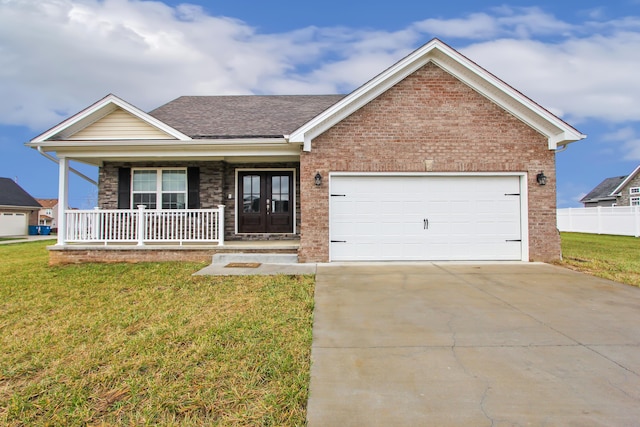 view of front of house with covered porch, a front yard, and a garage