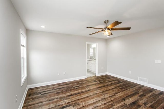 empty room with ceiling fan and dark wood-type flooring