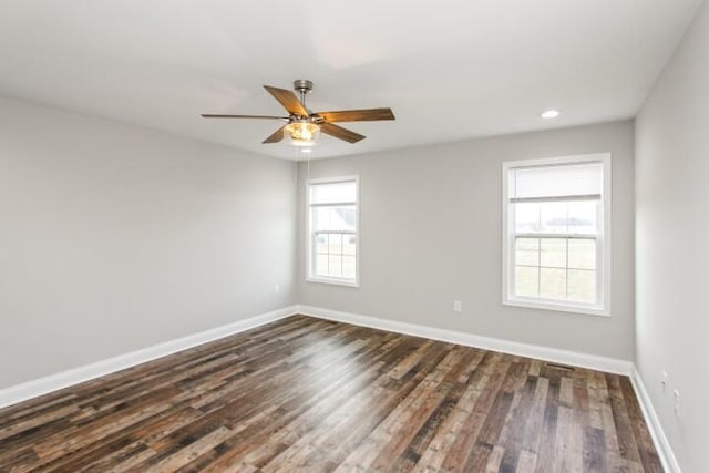 empty room with ceiling fan and dark hardwood / wood-style flooring