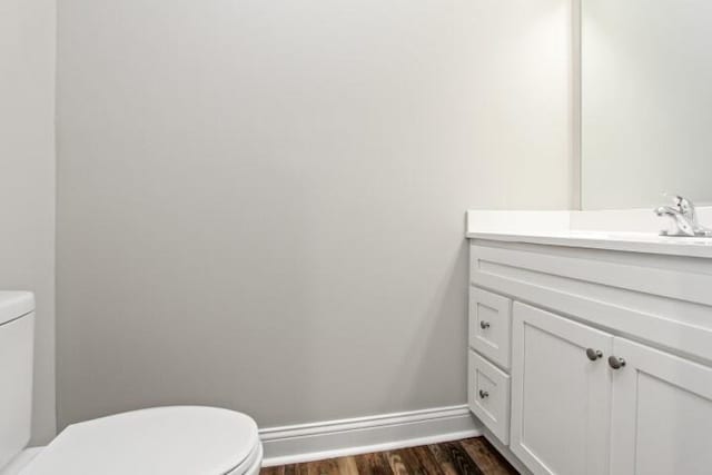 bathroom with hardwood / wood-style flooring, vanity, and toilet