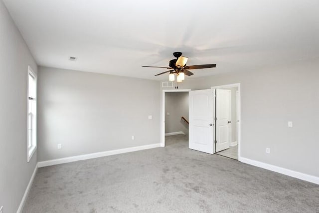 unfurnished room featuring light carpet, a wealth of natural light, and ceiling fan