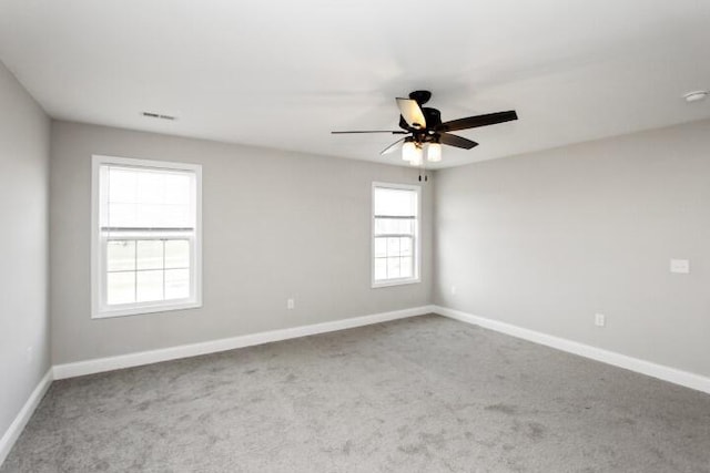 carpeted spare room with ceiling fan