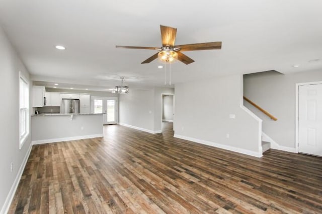 unfurnished living room featuring ceiling fan and dark wood-type flooring