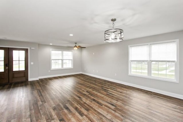 interior space with french doors, plenty of natural light, dark hardwood / wood-style floors, and ceiling fan with notable chandelier