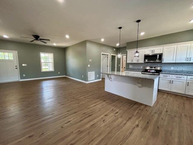 kitchen with pendant lighting, a center island, decorative backsplash, white cabinetry, and stainless steel appliances