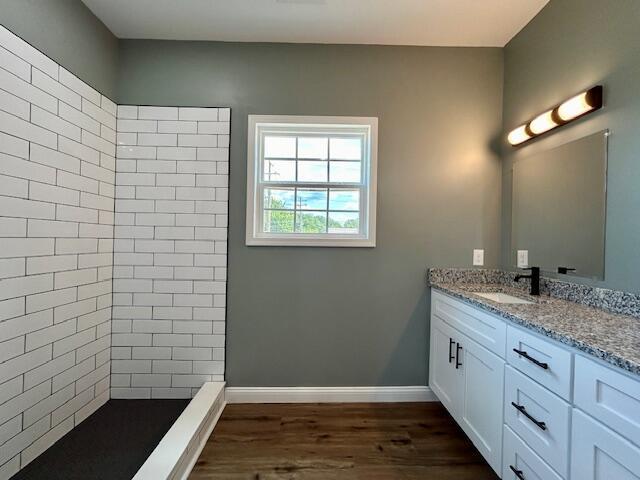 bathroom with hardwood / wood-style floors, vanity, and walk in shower