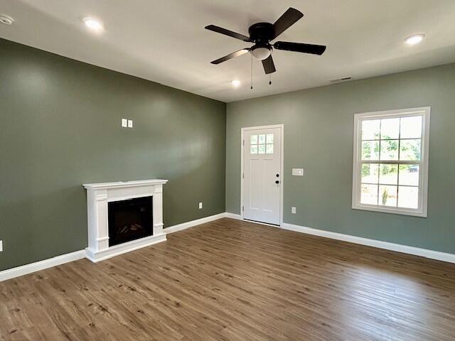 unfurnished living room with hardwood / wood-style flooring and ceiling fan