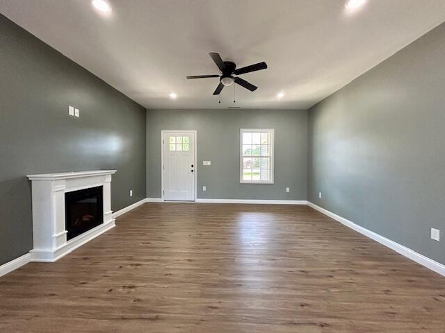 unfurnished living room with ceiling fan and dark hardwood / wood-style flooring