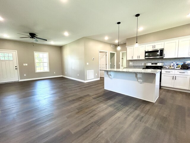 kitchen with a kitchen island with sink, white cabinets, hanging light fixtures, ceiling fan, and stainless steel appliances