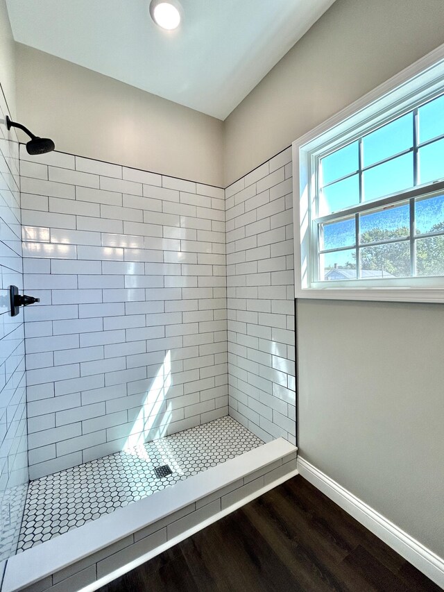 bathroom featuring hardwood / wood-style floors and tiled shower