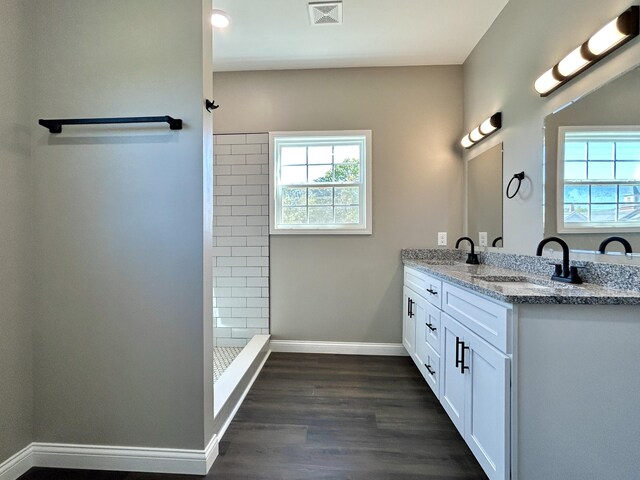 bathroom with a shower, wood-type flooring, and vanity