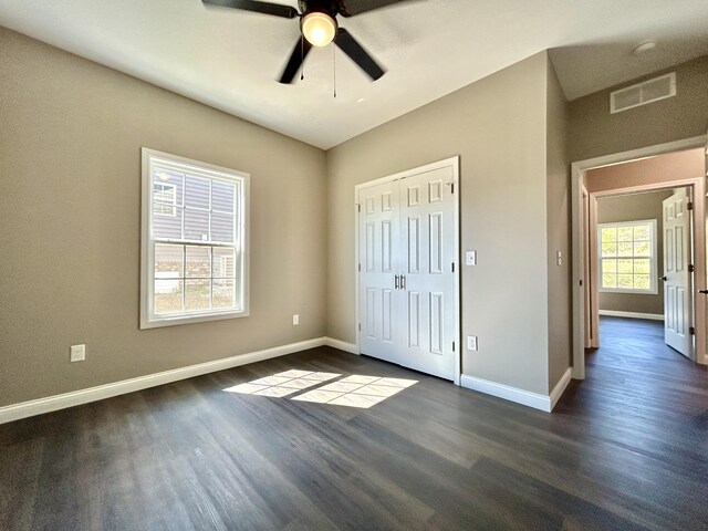 unfurnished bedroom with ceiling fan, a closet, and dark hardwood / wood-style floors