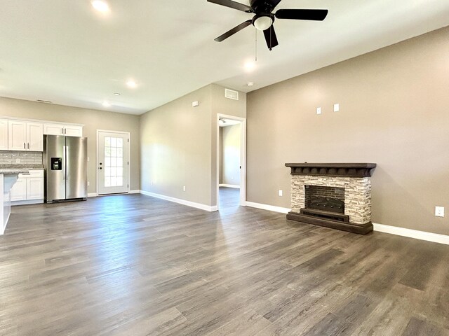 unfurnished living room featuring ceiling fan, a fireplace, and wood-type flooring