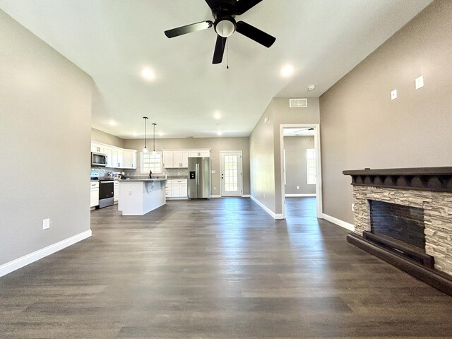 unfurnished living room featuring a fireplace, dark hardwood / wood-style floors, and ceiling fan