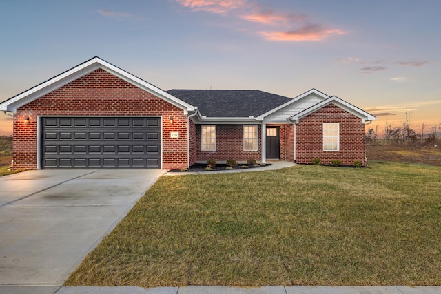 ranch-style home featuring a garage and a lawn