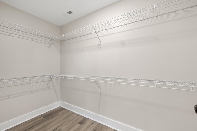 walk in closet featuring visible vents and wood finished floors