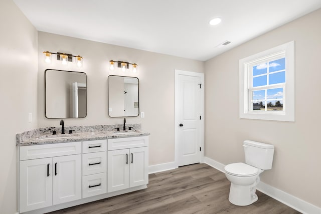 bathroom featuring vanity, hardwood / wood-style floors, and toilet