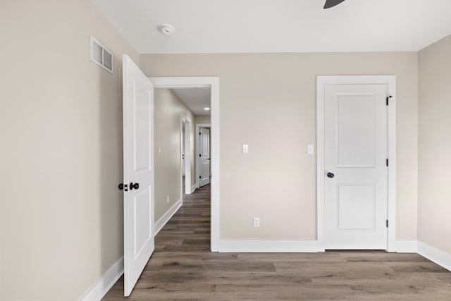 unfurnished bedroom featuring baseboards, visible vents, and wood finished floors