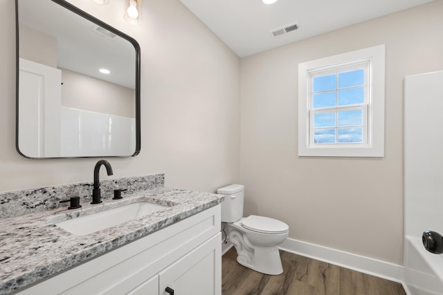 full bathroom with bathtub / shower combination, wood-type flooring, toilet, and vanity