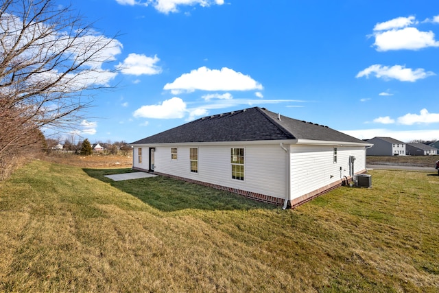 view of home's exterior with a shingled roof, central AC, and a yard