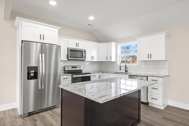 kitchen featuring white cabinetry, a center island, appliances with stainless steel finishes, and sink