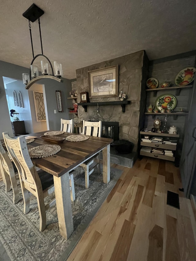 dining room featuring a textured ceiling and hardwood / wood-style flooring