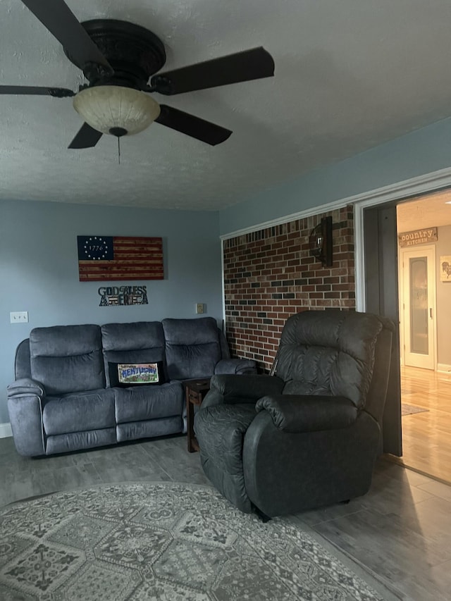 living room featuring hardwood / wood-style floors, a textured ceiling, and ceiling fan