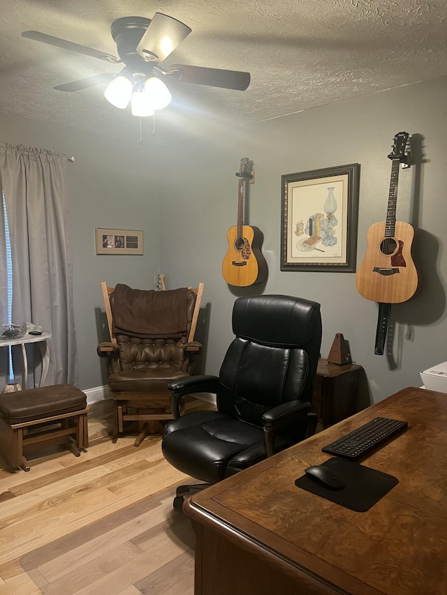 office featuring ceiling fan, light hardwood / wood-style floors, and a textured ceiling