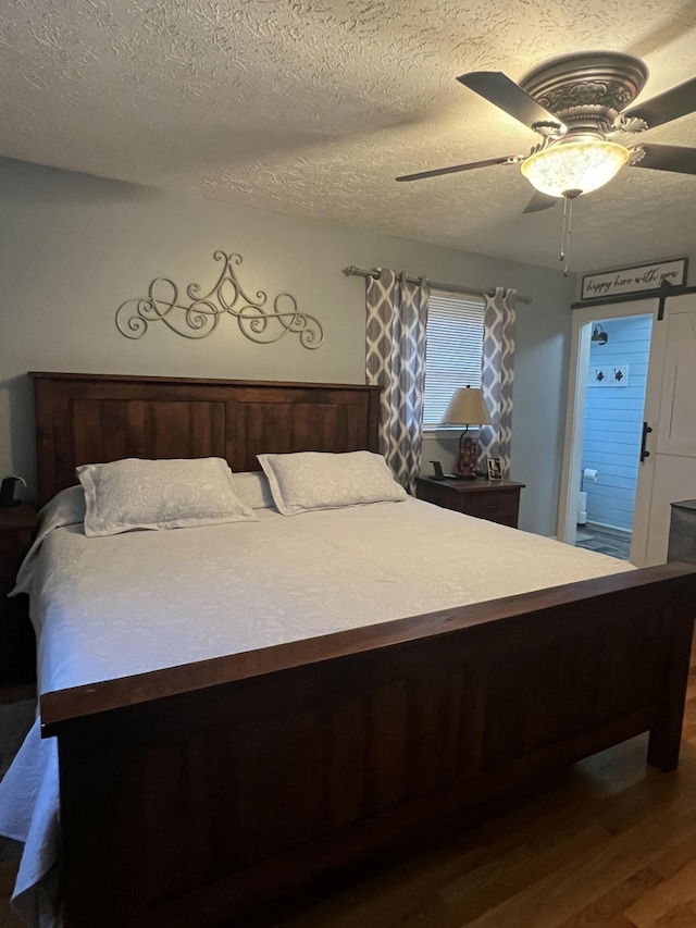 bedroom with hardwood / wood-style flooring, ceiling fan, and a textured ceiling